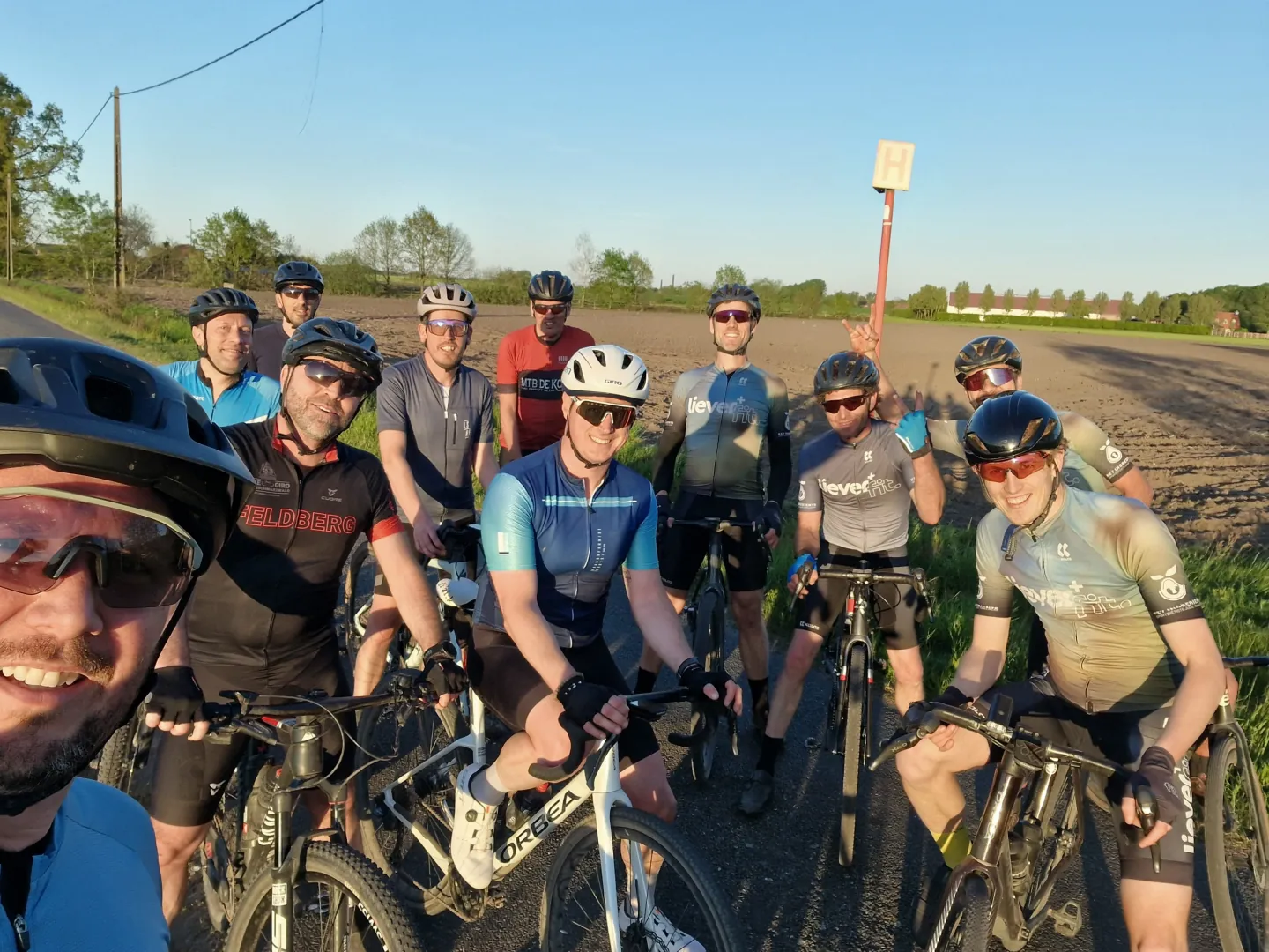 Een groep fietsers maakt samen een foto tijdens een rit door het open landschap.